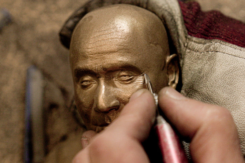 In the picture, you can see up close how the silversmith is shaping the folds of the bronze sculpture using his special chiseling tool.