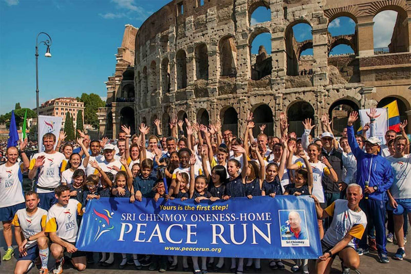 A group photo of the organizing team and some of the enthusiastic runners at the Sri Chinmoy Peace Run in Rome. In the background you can see the Roman Colosseum where a ceremonial programme was held in honour of the Peace Run.