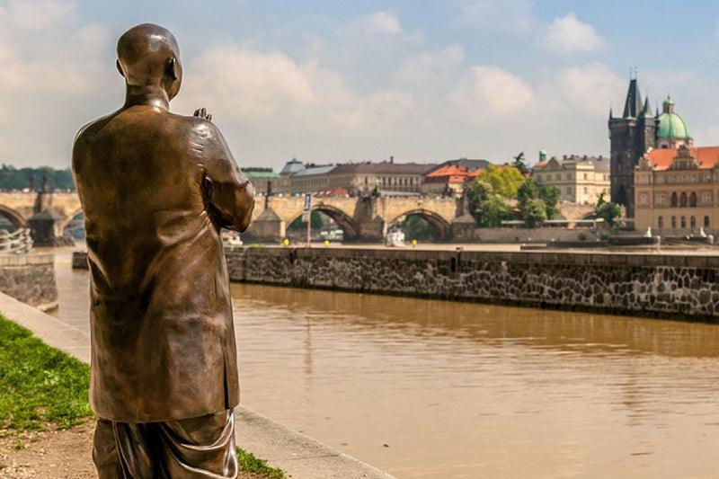 A life-size bronze statue of Sri Chinmoy is on display in Prague. The sculpture is a very inspiring work of art as it reminds us of our quest for peace. This inspiring work is placed directly on the river bank facing the city. In the background you can see the riverbank and the centre of Prague.