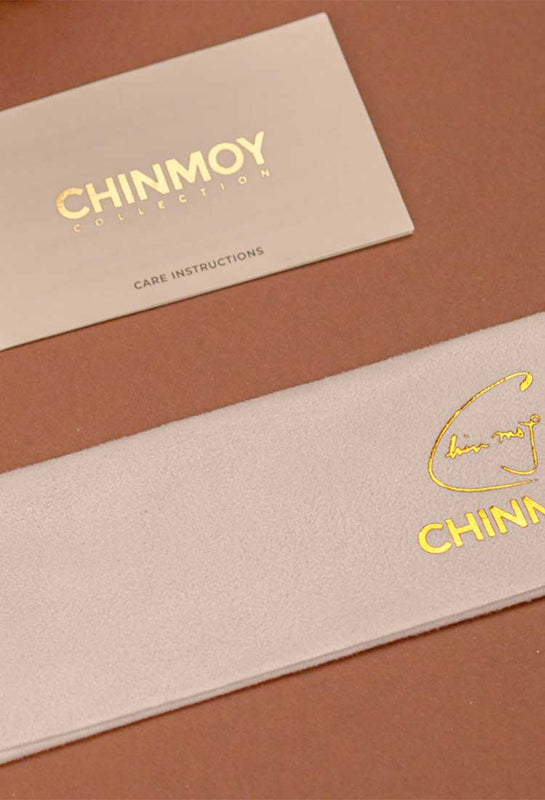 Chinmoy Collection care instuction card and microfiber clothing with gold Chinmoy logos